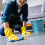 Cleaning Service concept. handsome asian man clean and removing dirt with equipment in living room.